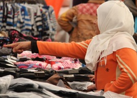 A girl picks her clothing in one of the shops. 